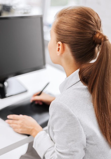 Conceito de negócios, escritório, escola e educação - empresária sorridente com desenho tablet no escritório