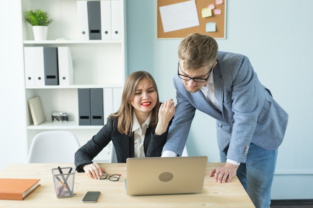 Conceito de negócios, estresse e pessoas - a mulher e o homem estão trabalhando juntos no escritório e pensando