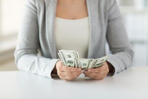 Conceito de negócios, finanças, economia, bancos e pessoas - close-up de mãos de mulher contando dinheiro em dólar