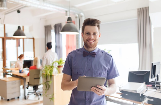 conceito de negócios, inicialização e pessoas - empresário feliz ou trabalhador de escritório masculino criativo com computador tablet pc