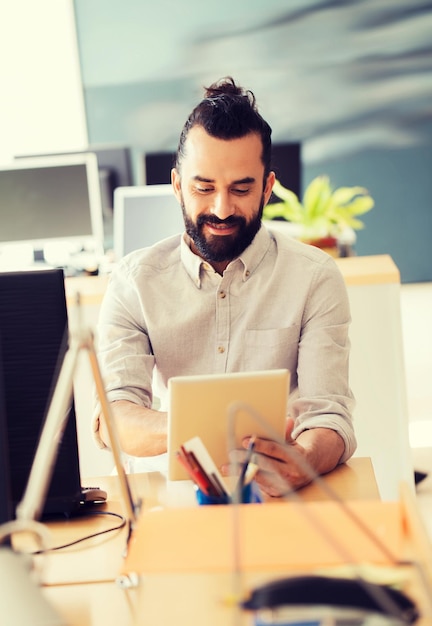 conceito de negócios, inicialização e pessoas - empresário feliz ou trabalhador de escritório masculino criativo com computador tablet pc