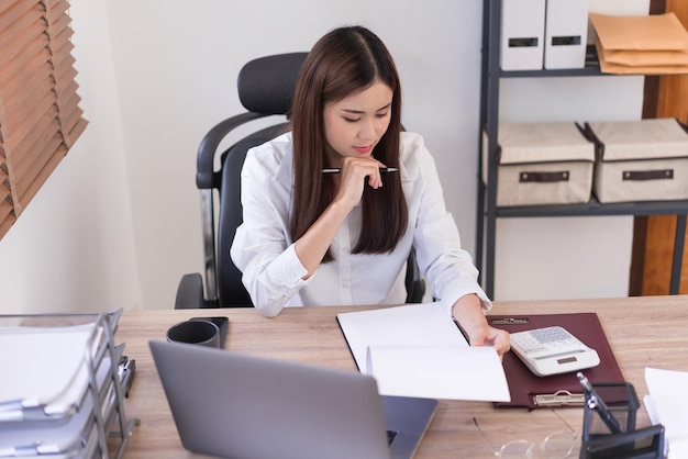 Conceito de negócios Mulher de negócios lendo documento de negócios para analisar o orçamento de investimento do projeto