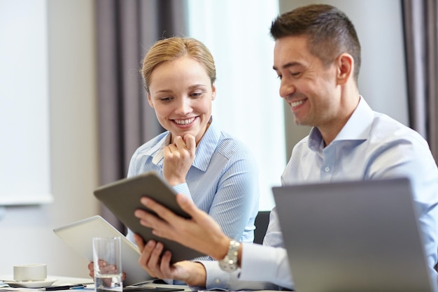 conceito de negócios, pessoas e tecnologia - equipe de negócios sorridente com computadores tablet pc reunidos no escritório