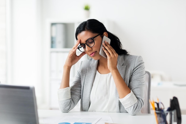 conceito de negócios, pessoas, prazo e tecnologia - empresária estressada ligando para smartphone no escritório