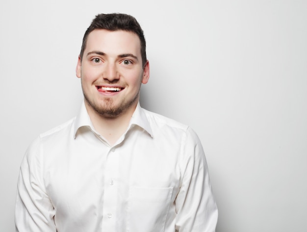 Conceito de negócios, sucesso e pessoas - homem de negócios jovem vestindo camisa branca, isolado no branco.