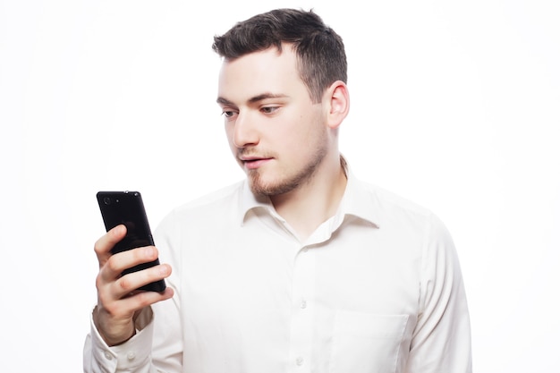 Conceito de negócios, tecnologia e pessoas - belo homem de negócios feliz lendo um SMS em um smartphone contra um fundo branco