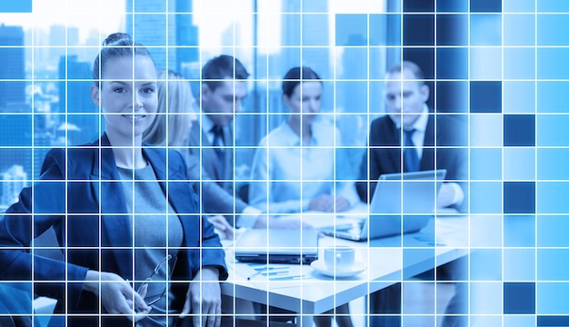 Foto conceito de negócios, tecnologia e pessoas - empresária sorridente e equipe no escritório sobre fundo de grade quadrada azul