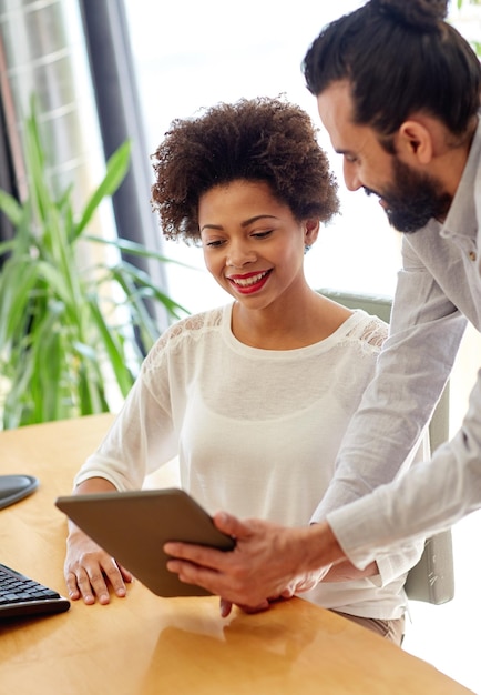 conceito de negócios, tecnologia, inicialização e pessoas - equipe criativa feliz com computadores tablet pc no escritório