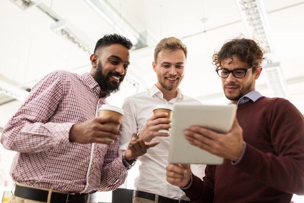 conceito de negócios, tecnologia, pausa e pessoas - equipe criativa feliz com computador tablet tomando café e conversando no escritório