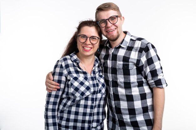 Conceito de nerds, geek, com óculos e pessoas engraçadas - casal engraçado de óculos se abraçando no branco