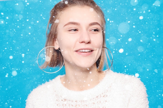 Conceito de neve, inverno, natal, estilo de vida saudável, felicidade e pessoas - retrato de uma jovem com emoções felizes. rindo, sorrindo, raiva, suspeita, medo, surpresa sobre fundo de neve