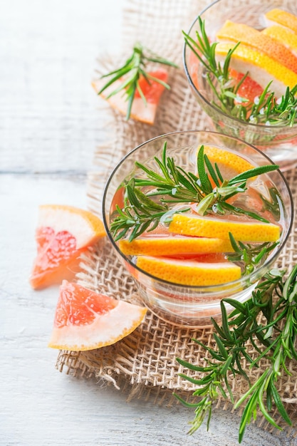 Conceito de nutrição saudável de fitness de saúde fresco fresco toranja alecrim infundido coquetel de água desintoxicação bebida limonada para dias de verão de primavera em uma mesa de madeira branca