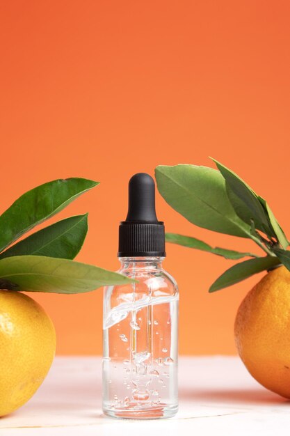 Conceito de óleo essencial de laranja orgânico natural para cuidados de saúde do rosto e corpo da pele Hidratante aromaterapia tratamento de desintoxicação efeito anti-stress Frutas frescas folhas verdes fundo laranja