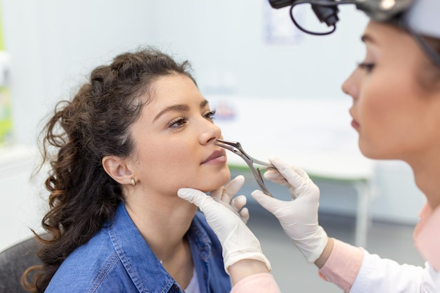 Conceito de otorrinolaringologia Otorrinolaringologista verificando nariz com otoscópio de seu paciente no hospital Conceito de alergia de sinusite congestão nasal