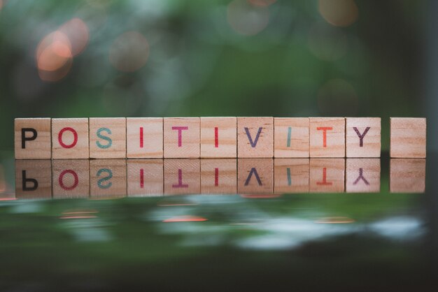 Conceito de palavras POSITIVIDADE cubo de palavras no chão de reflexão bokeh desfocar o fundo