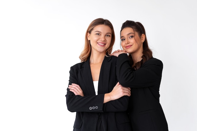 Conceito de parceria nos negócios duas jovem empresária vestida de terno formal preto em pé estúdio isolado fundo branco