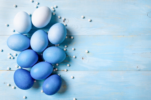 Conceito de Páscoa Ombre eggs em cores azuis sobre fundo azul de madeira, com espaço de cópia de texto. Vista de cima para baixo ou plano. Cores azuis clássicas na Páscoa 2020