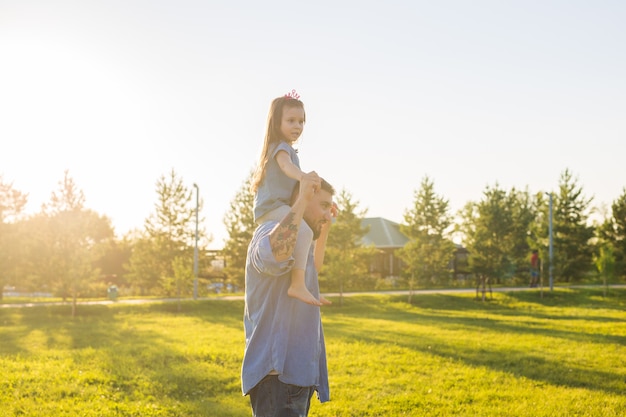 Conceito de paternidade, família e filhos - pai e filha se divertindo e brincando na natureza.