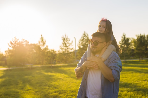 Conceito de paternidade, família e filhos - pai e filha se divertindo e brincando na natureza.