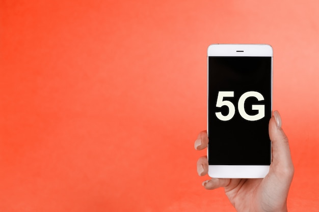 Foto conceito de perigo, mão segurando um telefone com um símbolo 5g. o conceito de rede 5g