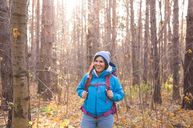 Conceito de pessoas, caminhada e natureza - turista feminina andando na floresta de outono.