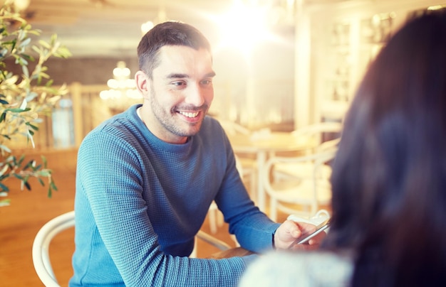 conceito de pessoas, comunicação e namoro - casal feliz conversando no café ou restaurante