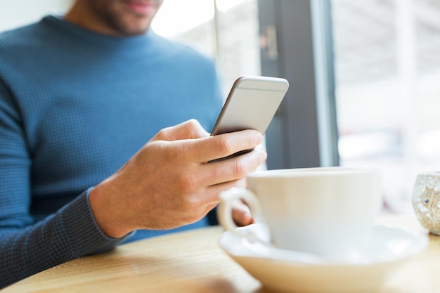 conceito de pessoas, comunicação e tecnologia - close-up do homem com smartphones no café