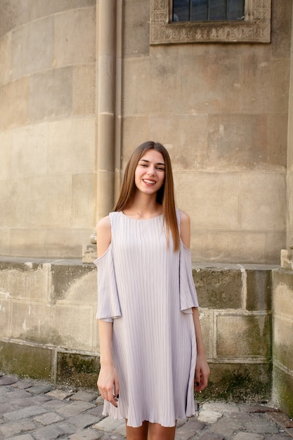 Conceito de pessoas, emoções, natural, beleza e estilo de vida - jovem bela mulher alegre andando na velha rua na cidade tropical. Menina bonita olhando para você e sorrindo