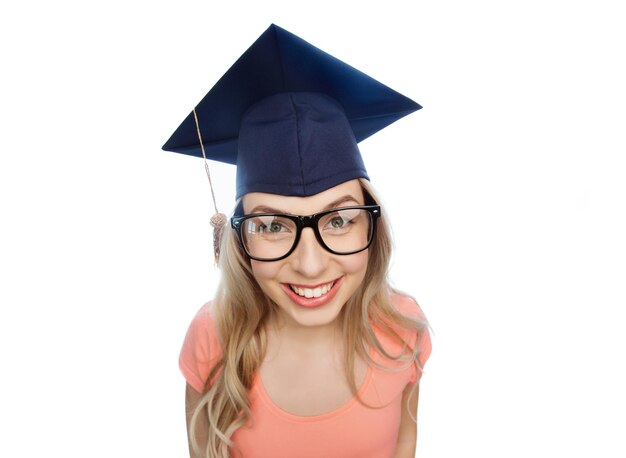 Foto conceito de pessoas, graduação e educação - jovem estudante sorridente em capelo e óculos