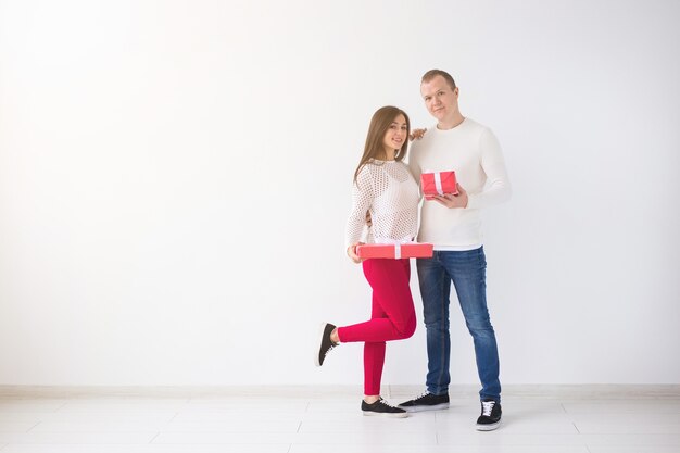 Conceito de pessoas, natal, aniversário, feriados e dia dos namorados - jovem feliz e mulher com caixas de presente em fundo branco com espaço de cópia.