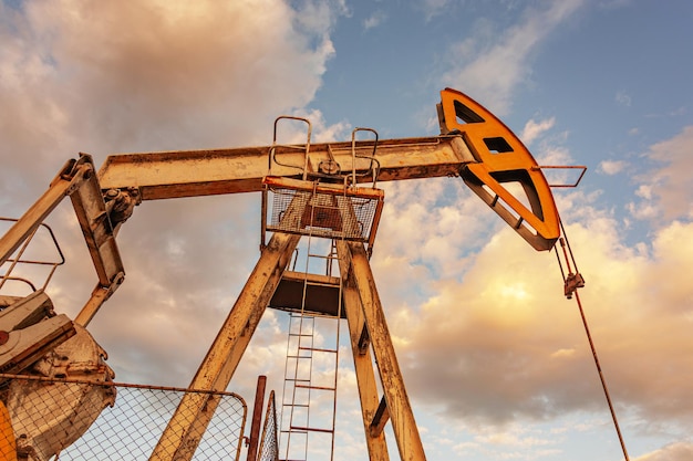 Conceito de petróleo. Equipamento de bomba de óleo. Produção de petróleo e gás. Local do campo petrolífero. Pump Jack está funcionando. Torres de perfuração para a produção de combustíveis fósseis e produção de petróleo bruto. Crise global. Guerra aos preços do petróleo.