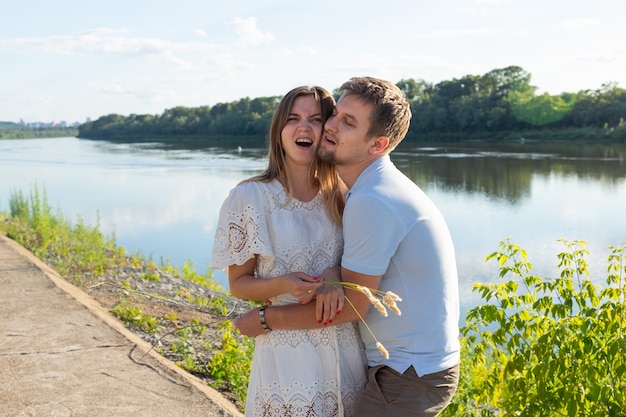 Conceito de piada, relacionamento e humor - retrato de um casal apaixonado brincando na natureza.