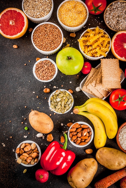 Conceito de plano de fundo de alimentos diet, produtos de carboidratos saudáveis (carboidratos) - frutas, legumes, cereais, nozes, feijão, fundo de concreto azul escuro vista superior espaço de cópia