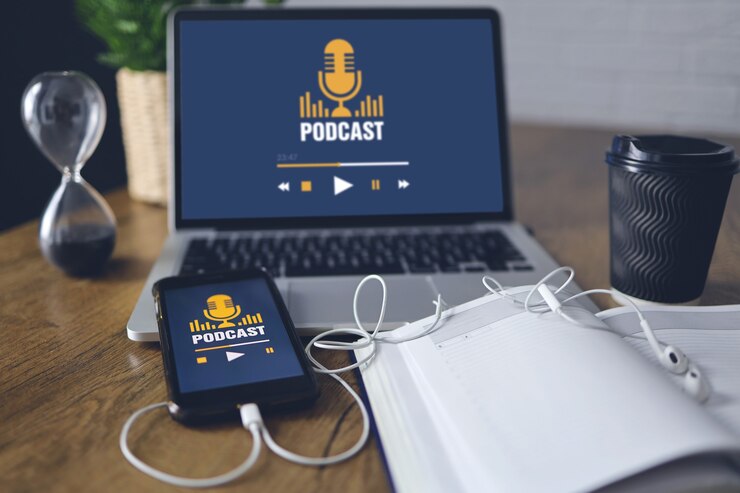 Foto conceito de podcast na tela do laptop e smartphone, mesa de madeira.