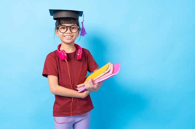 Conceito de pós-graduação e educação, estudante de criança asiática menina tailandesa com livros e fone de ouvido usando chapéu de bacharel