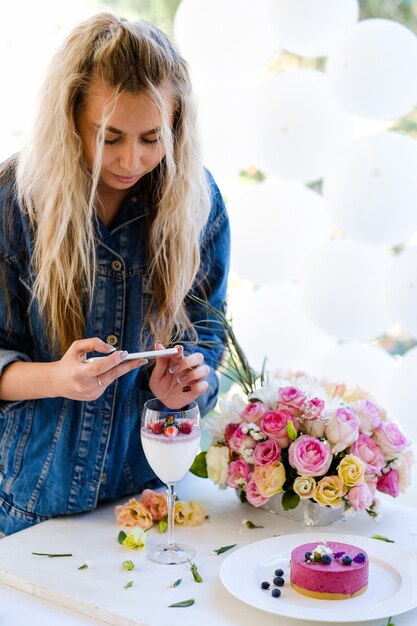 Conceito de preparação de festa de foto de smartphone de blogueiro de mulher. processo de criação