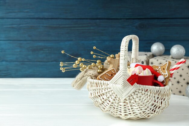 Conceito de presente com cesta de Natal na mesa de madeira branca