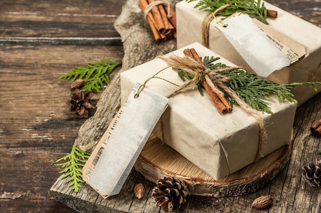 Conceito de presente de desperdício zero. embalagem ecológica de natal ou ano novo. caixas festivas em papel craft com diferentes decorações orgânicas. fundo de madeira vintage, close-up