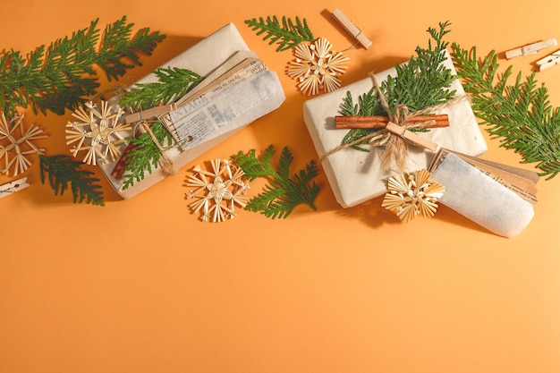 Conceito de presente de desperdício zero. Embalagem ecológica de Natal ou Ano Novo. Caixas festivas em papel craft com diferentes decorações orgânicas. Luz dura na moda, sombra escura, vista superior, configuração plana