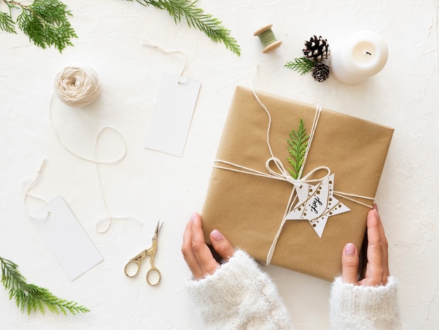 Conceito de presente de Natal. Presente de Natal de embrulho caseiro com papel artesanal, ferramentas e decorações. Vista do topo