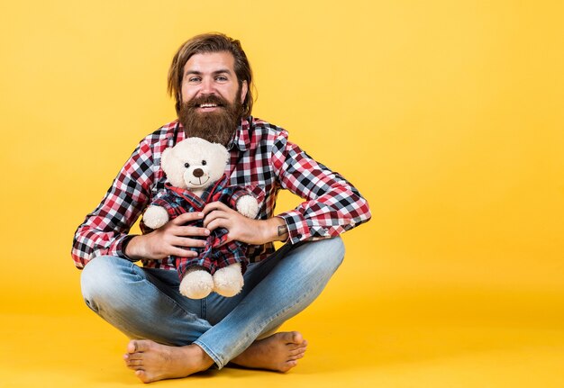 Conceito de presentes e feriados. isto é para você. hipster como brinquedo animal. celebração da festa de aniversário nas férias. sinta felicidade. homem com barba segura urso de brinquedo fofo. homem segura o ursinho de pelúcia. copie o espaço.