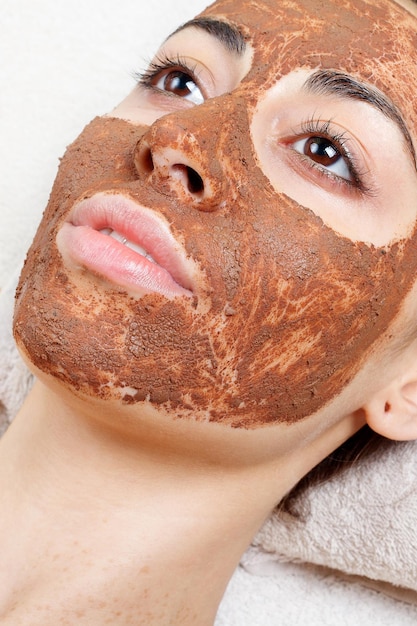 Foto conceito de primavera, saúde, pessoas, juventude e beleza - máscaras faciais de frutas caseiras naturais. fruta fresca. mulher de spa, aplicação de máscara de limpeza facial. tratamentos de beleza