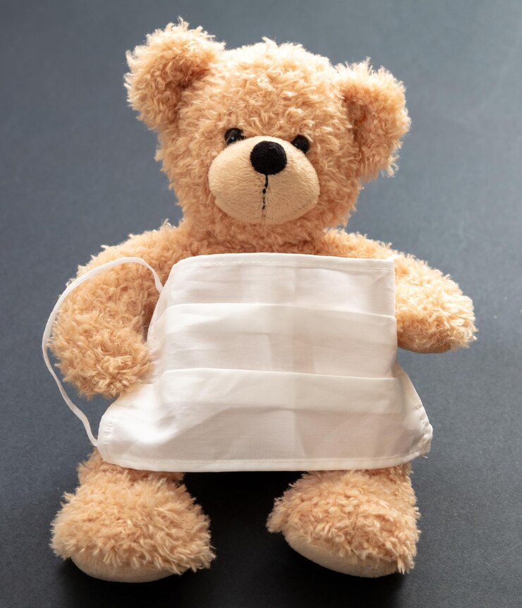 Foto conceito de proteção contra coronavírus e poluição urso de pelúcia com máscara facial protetora em fundo cinza