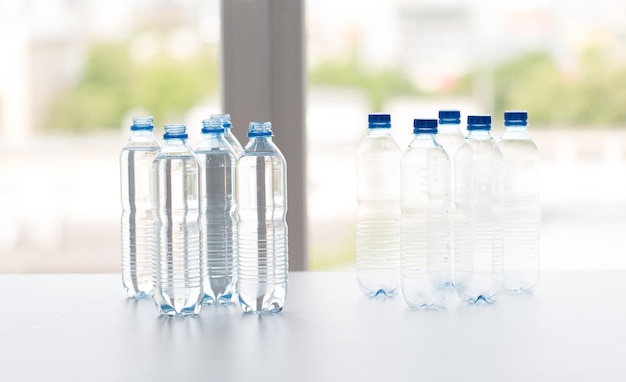 conceito de reciclagem, alimentação saudável e armazenamento de alimentos - fechamento de garrafas plásticas com água potável pura na mesa