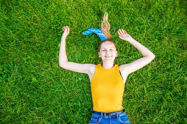 Conceito de relaxamento e meditação. Jovem loira encontra-se na grama verde