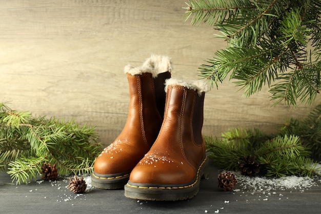 Conceito de roupas de inverno com botas na mesa de madeira escura.