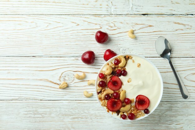 Conceito de saboroso café da manhã com iogurte na mesa de madeira