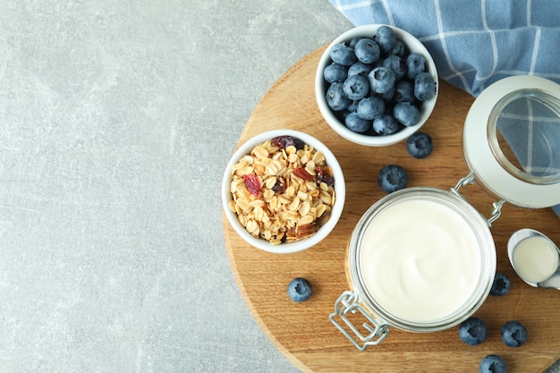 Conceito de saboroso café da manhã com iogurte na mesa texturizada cinza