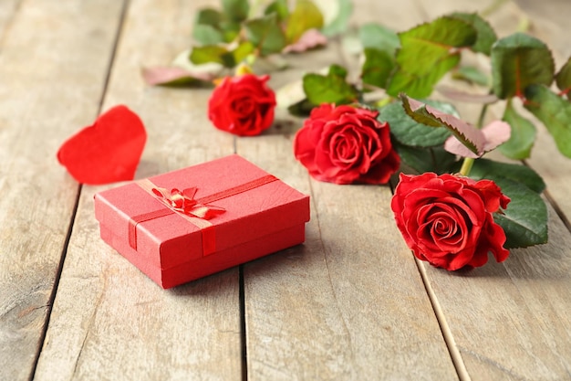 Conceito de São Valentim Rosas vermelhas frescas e caixa de presente na mesa de madeira