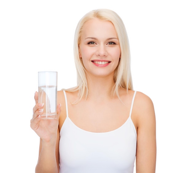 conceito de saúde e beleza - jovem sorridente com copo de água